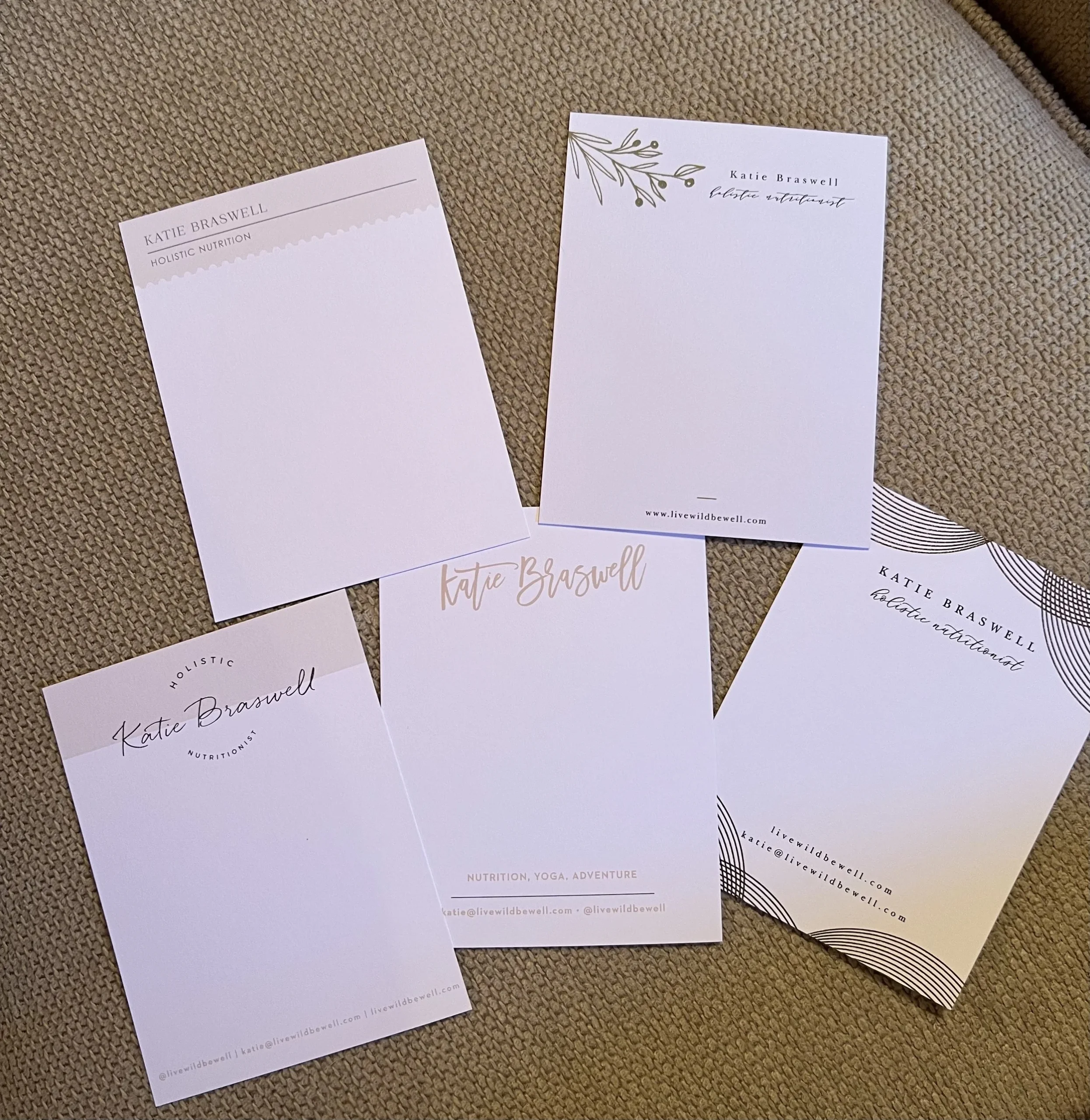 Five notepad design variations for Katie Braswell, Holistic Nutritionist, with different header styles: olive branch, tan block, script logo, and geometric line art, listing livewildbewell.com contact info