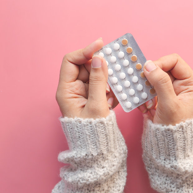 Hands holding a blister pack of birth control pills