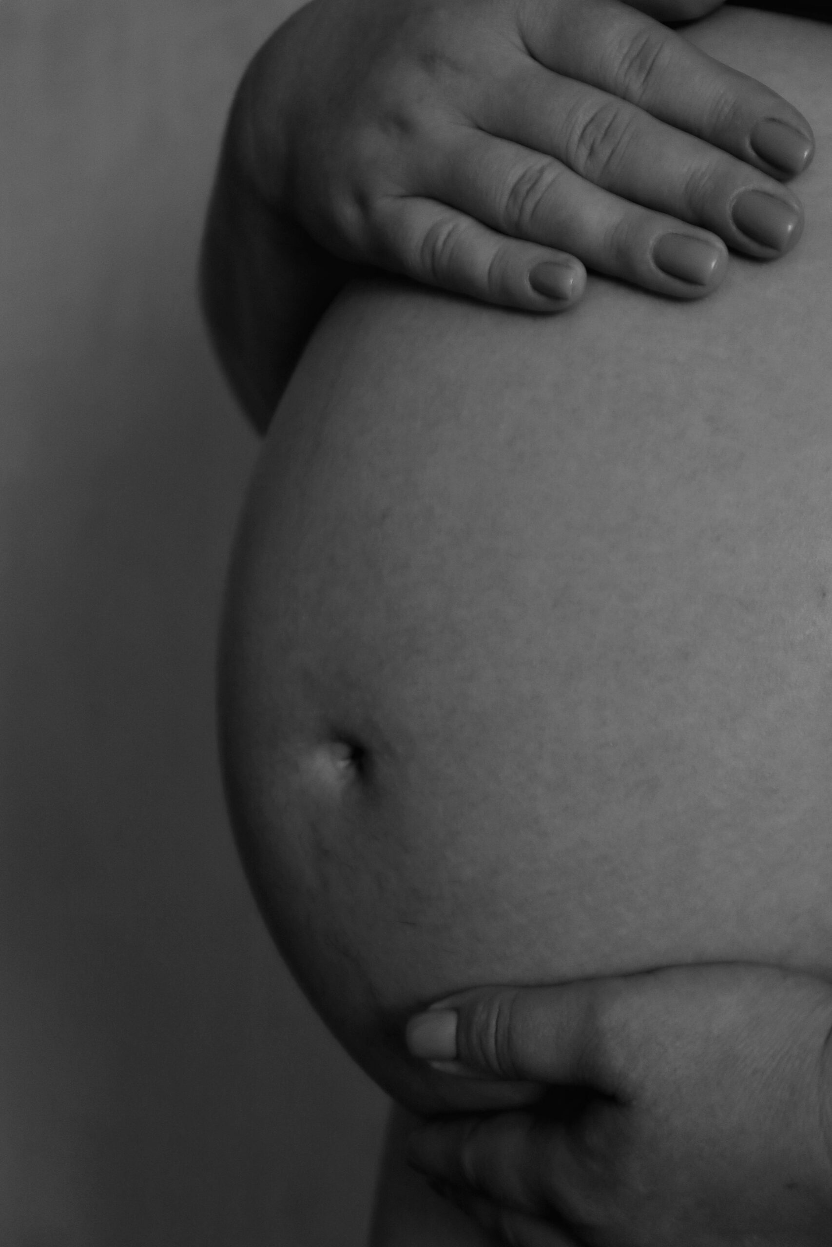 Pregnant woman holding her belly.